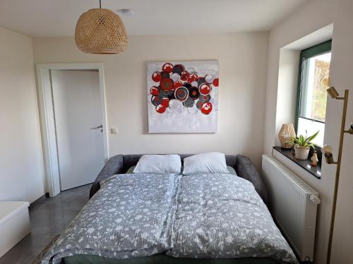 ein Schlafzimmer mit einem Bett und einem Gemälde an der Wand in der Unterkunft Studio Keppelborn in Sankt Vith