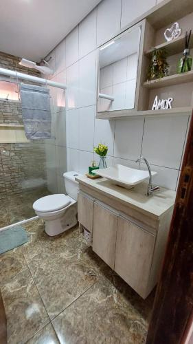 a bathroom with a toilet and a sink at Recanto da Saudade, 3 Quartos, Piscina, Churrasqueira in Boituva
