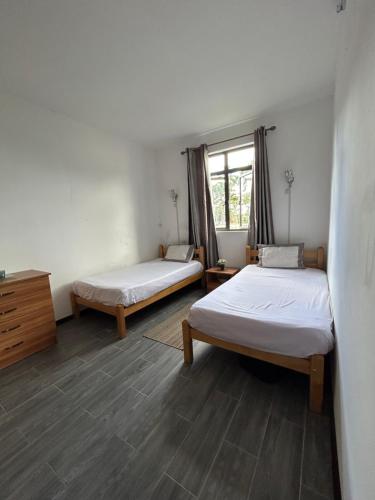 a room with two beds and a window at The cozy nest in Curepipe