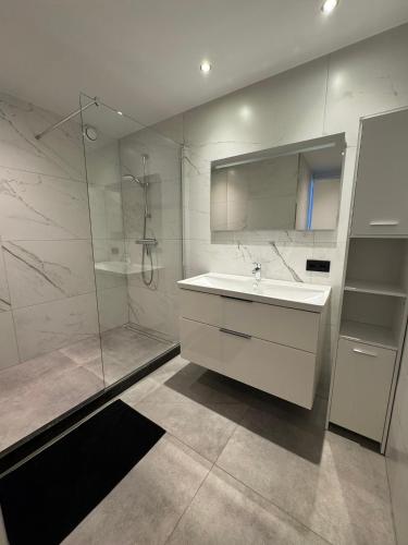 ein weißes Badezimmer mit Waschbecken und Dusche in der Unterkunft Boulevard 3E in Arnhem