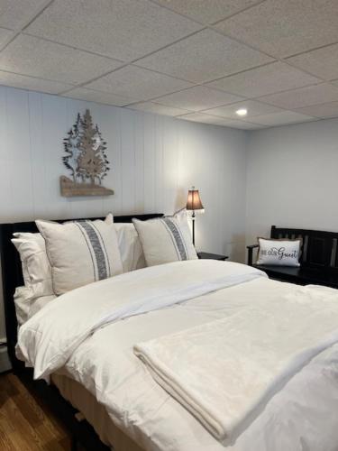 a bedroom with a white bed with a christmas tree on the wall at Beacon Hudson Hideaway in Beacon