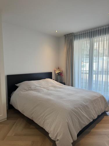 ein Schlafzimmer mit einem großen Bett und einem Fenster in der Unterkunft Boulevard 3E in Arnhem