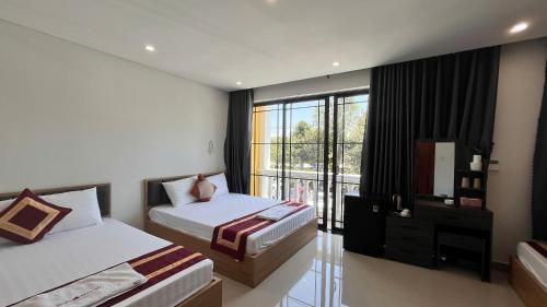 a hotel room with two beds and a window at Luxury Hotel in Tây Ninh