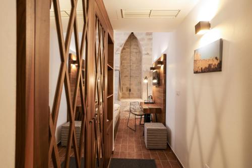 a hallway with a bathroom with a toilet and a table at Heritage Hotel Maskovica Han in Pakoštane