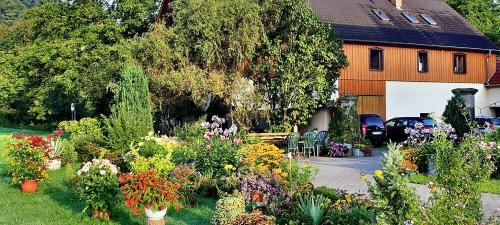 a garden with flowers in front of a house at Landhaus Fröde in Kurort Rathen