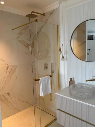 a bathroom with a shower with a sink and a mirror at Sea view in Dubrovnik