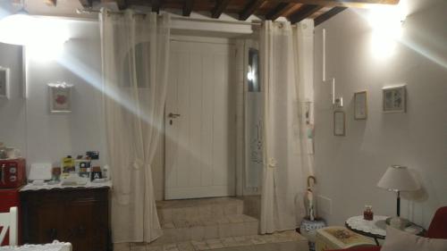 a hallway with a white door with curtains in a room at La Libellula in Capannoli