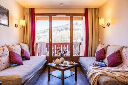a living room with two couches and a table at Résidence Pierre & Vacances l'Albane in Vars