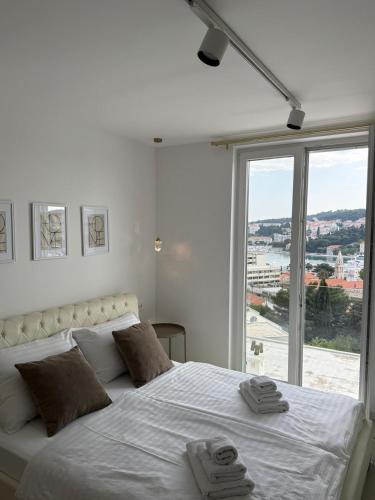 a bedroom with a large white bed with a large window at Sea view in Dubrovnik