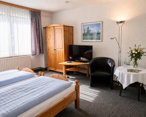 a bedroom with a bed and a desk with a computer at Mecklenburger Hof in Parchim