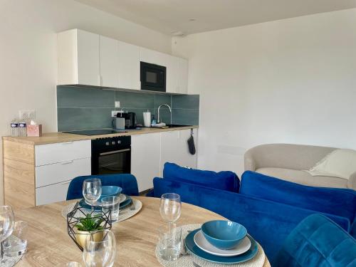 a living room with a blue couch and a table at Duplex d Iroise rénové 2 chambres Centre Gouesnou Parking & Wifi in Gouesnou