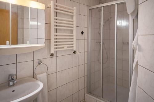 a white bathroom with a shower and a sink at Mecklenburger Hof in Parchim