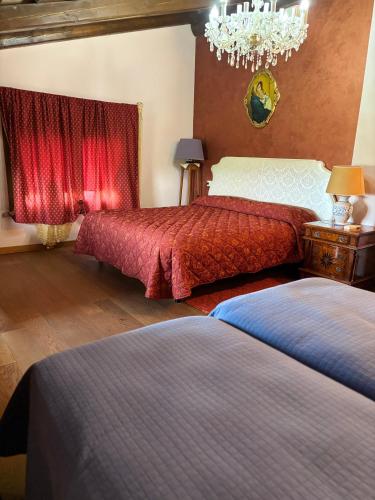 a bedroom with two beds and a chandelier at Terra e Mare in Santa Maria Pietrafitta