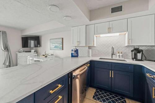 a kitchen with blue cabinets and a white counter top at Oceanfront Condo, Steps to the Beach in Myrtle Beach