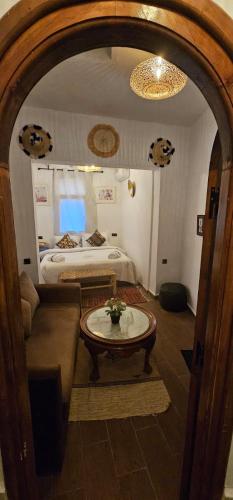 a living room with a table and a bed at Dar Nomads in Chefchaouen