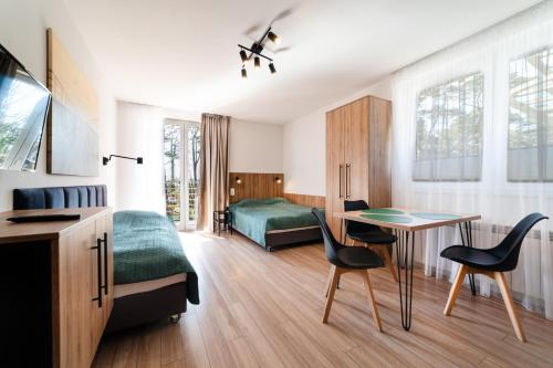 a bedroom with a bed and a desk and a table at Willa Juranda in Jurata