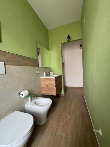 a green bathroom with a toilet and a sink at Vintage House in Asciano
