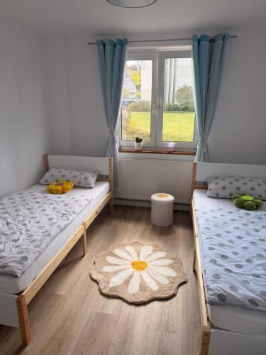 two beds in a room with a window at Cozy Home in Schramberg