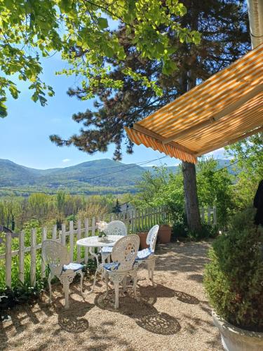 a patio with a table and chairs and a fence at Fecskefészek vendégház in Nagymaros