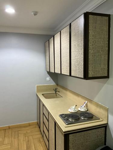 a kitchen with a stove and a sink at اجنحه البيداء فرع الدفاع in Medina