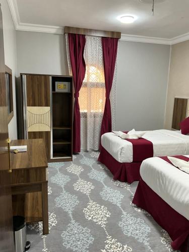 a hotel room with two beds and a window at اجنحه البيداء فرع الدفاع in Medina