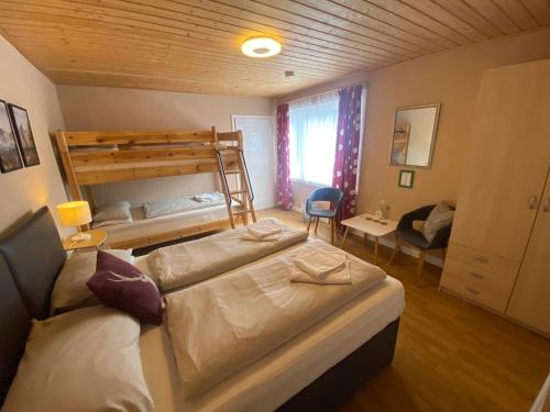 a bedroom with two beds and a bunk bed at Pension Julia in Feld am See