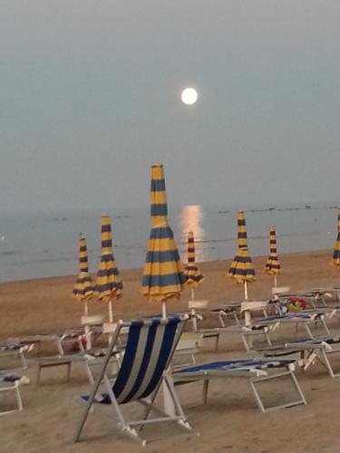 a group of chairs and umbrellas on a beach at Al Villino del Sole in Fano