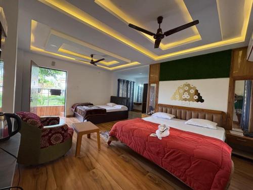 a bedroom with a large red bed and a couch at North Queen Resort in Mal bazar
