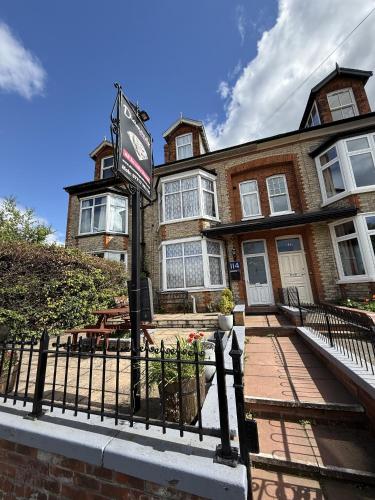 a brick house with a sign in front of it at Diamonds Guest House in York