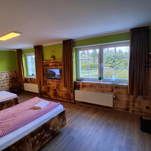 a bedroom with two beds and two windows at Gaststätte Zur Hahnenquelle in Kirchhundem