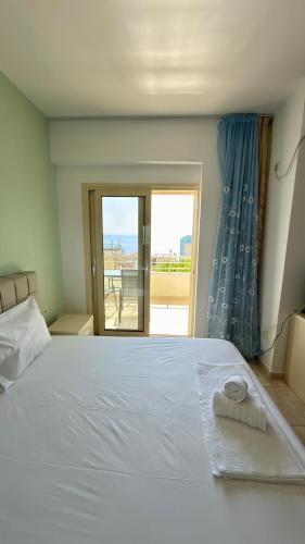 a bedroom with a large white bed with a view at Dhermi Light Rooms in Dhërmi
