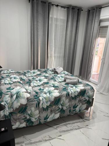 a bedroom with a bed with a green and white blanket at Mister House in Fiumicino