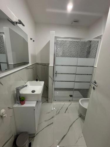 a white bathroom with a sink and a shower at Mister House in Fiumicino