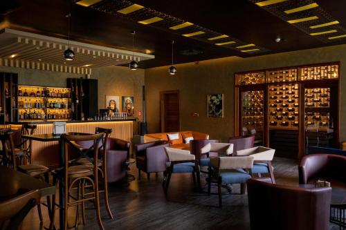 a restaurant with tables and chairs and a bar at Virunga Inn Resort & Spa in Kinigi