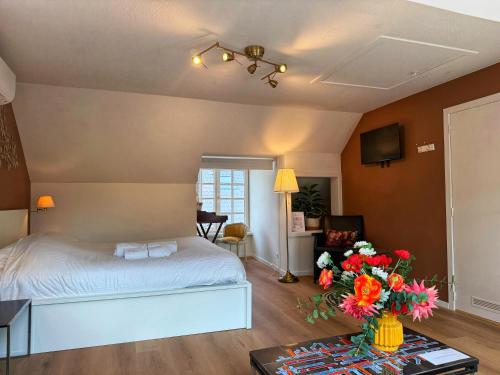 a bedroom with a bed and a vase of flowers on a table at Clemanbruges in Bruges