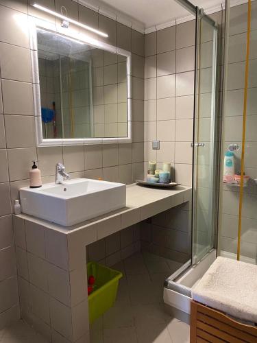 a bathroom with a sink and a mirror and a shower at Wave Rider Villa in Kouvéla