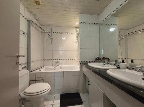 a bathroom with two sinks and a toilet and a tub at Noax gite Durbuy in Durbuy