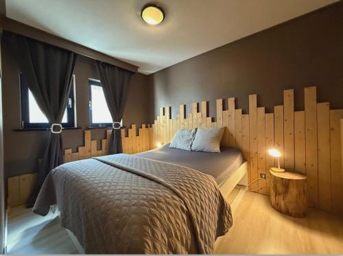 a bedroom with a bed with a wooden headboard at Noax gite Durbuy in Durbuy