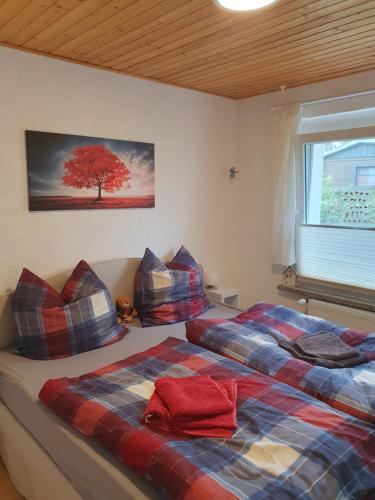 a bedroom with two beds and a tree on the wall at Ferienwohnung am Schwielochsee in Schwielochsee