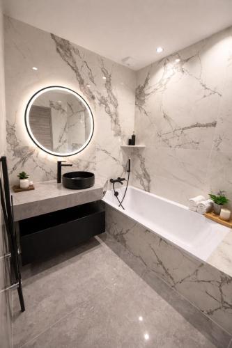 a bathroom with a sink and a mirror and a tub at Maison moderne in Saint-Julien-de-Concelles
