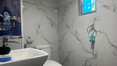 a bathroom with a black and white marble wall at Madu Guest in Nuwara Eliya