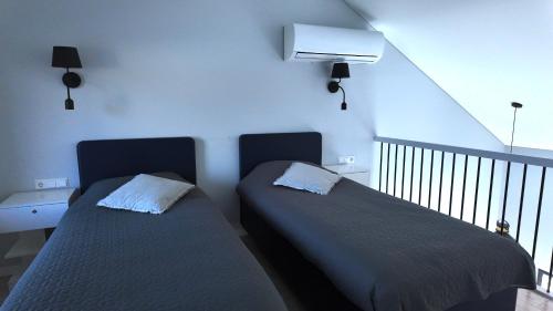 two beds sitting in a room with a staircase at Bele Lofts in Karmėlava