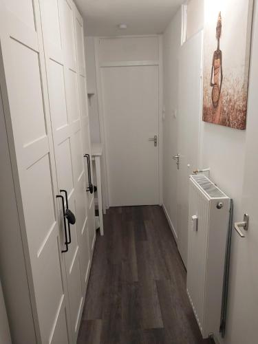 a hallway with a white door and a hallway with wooden floors at Maison-Home-ZuHause in La Calamine