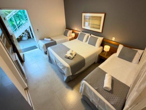 a hotel room with two beds and a couch at Mar e Praia Hotel in Ubatuba