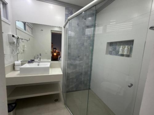 a bathroom with a sink and a shower at Mar e Praia Hotel in Ubatuba