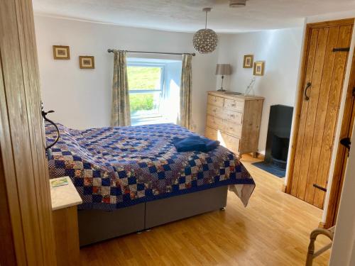 a bedroom with a bed and a television and a window at Brookside in Langthwaite
