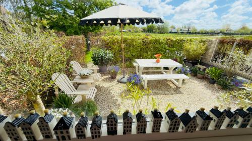 a patio with a table and chairs and an umbrella at Tulipa Near Beach & Dunes with Free Parking in Noordwijkerhout