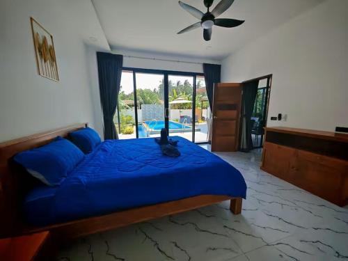 a bedroom with a blue bed with a cat sitting on it at Beautiful accommodation on Lipa Noi in Nathon Bay