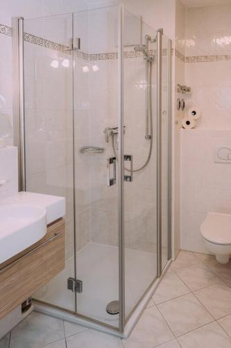 a bathroom with a shower with a sink and a toilet at Europa Residenz Bad Füssing in Bad Füssing