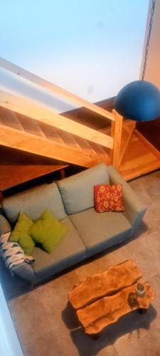 a couch with pillows sitting under a bunk bed at Amapolas monoambiente in El Bolsón
